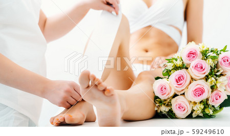Hair removal using wax strips at the legs in beauty parlor Hair removal using wax strips at the legs in beauty parlor 59249610