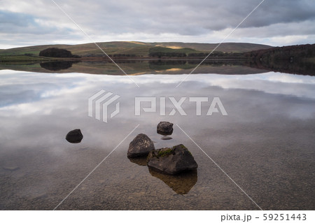 Serene water of Malham Tarn with the reflection of the afternoon sun on the hills, Yorkshire Dales, 59251443