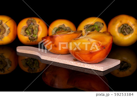 Sweet orange persimmon isolated on black glass Sweet orange persimmon isolated on black glass 59253384