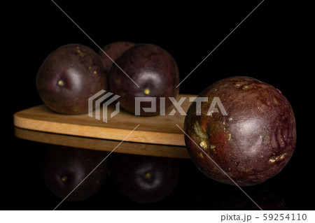 Sweet dark passion fruit isolated on black glass 59254110