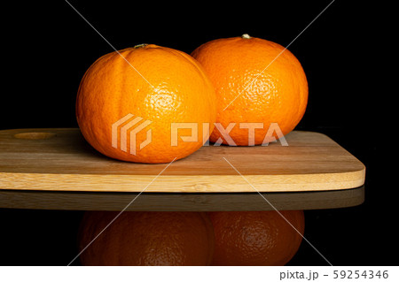 Fresh orange mandarine isolated on black glass 59254346