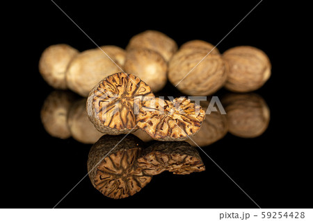 Dry brown nutmeg isolated on black glass Dry brown nutmeg isolated on black glass 59254428