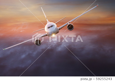 Commercial airplane flying above dramatic clouds. 59255243