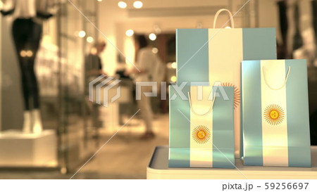 Flag of Argentina on the paper shopping bags against blurred store entrance. Retail related 3D 59256697