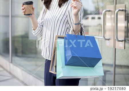 買い物を終えて店を出る若い女性 買い物を終えて店を出る若い女性 59257080