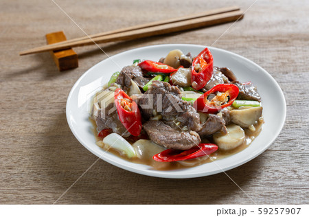 close up of stir fried beef with oyster sauce in a ceramic dish on wooden table. 59257907