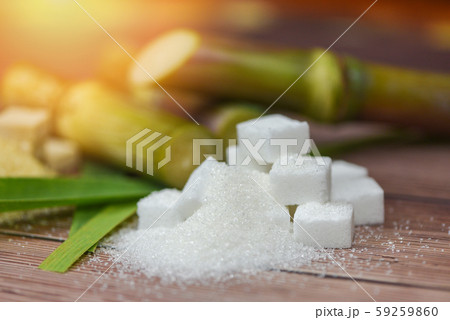 White sugar cubes and sugar cane on wooden table 59259860