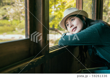 traveler wearing hat leaning against open window traveler wearing hat leaning against open window 59261336
