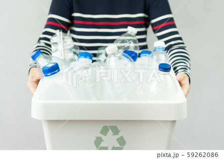 A woman hold a sorted recycle bin full of single-use plastic beverage bottles and other plastic waste. Waste segregation, Single-use plastic problems, Environmental awareness, Plastic Recycle concept. A woman hold a sorted recycle bin full of single-use plastic beverage bottles and other plastic waste. Waste segregation, Single-use plastic problems, Environmental awareness, Plastic Recycle concept. 59262086
