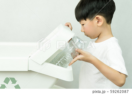 A kindergarten boy learning to sorted plastic water bottles into the recycle bin separated from others. Waste segregation, Single-use plastic problems, Environmental awareness, Zero waste concept. 59262087