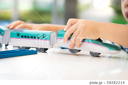 Close up of a little child's hands playing, assembling the colorful plastic railway track. Educational hands-on toys, Kids Thinking skills, Brain development, JR, Popular Japanese Model train. 59262214