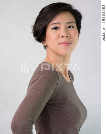 Portrait of a smart looking asian middle aged woman in her 40s smiling feeling satisfied and confident. Casual Look, Short hairstyle, Wringkle Aging, Middle aged woman beauty and health concept. 59263983