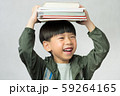 'Back to school' A lovely little boy having fun holding his lesson books on his head. Education, Smart kids, Child development, Genius, Kids Intelligence, High IQ, Emotional Quotient, IQ-EQ concept. 59264165