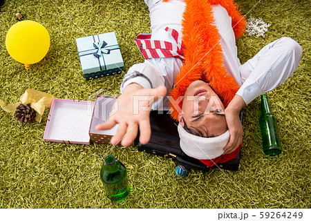 Young handsome employee celebrating Christmas at workplace 59264249