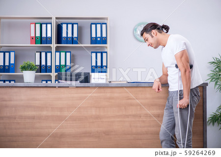 Young man at hospital reception desk Young man at hospital reception desk 59264269