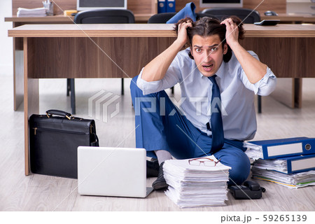 Young male employee and too many work in the office Young male employee and too many work in the office 59265139