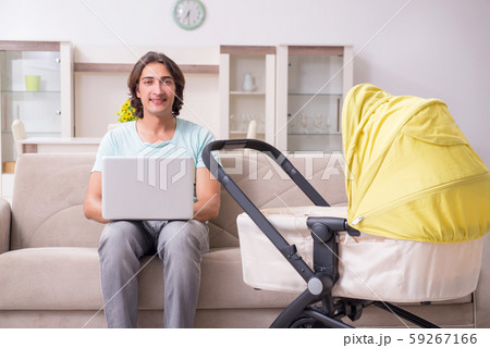 Young man looking after baby in pram 59267166