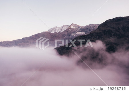 Snow covered mountain peaks in the clouds. Snow covered mountain peaks in the clouds. 59268716