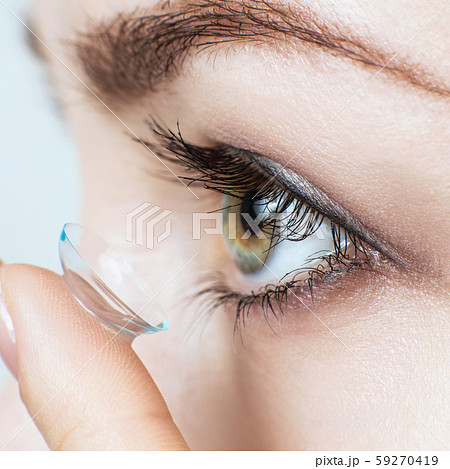 Close-up shot of young woman wearing contact lens. Close-up shot of young woman wearing contact lens. 59270419