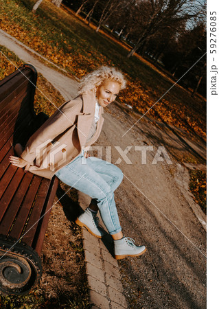 Woman sitting on the bench at autumn city park Woman sitting on the bench at autumn city park 59276085