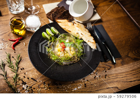 Scallop ceviche served in black bowl with liquid ice smoke 59279506