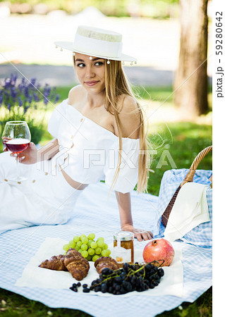 Portrait of happy young woman having rest on picnic in park 59280642