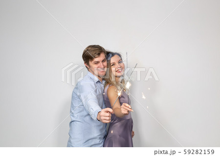 Holidays, family and celebrations concept - young couple hugging with crossed bengals light or Holidays, family and celebrations concept - young couple hugging with crossed bengals light or 59282159