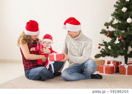 Happy couple with baby celebrating Christmas together at home. 59286203