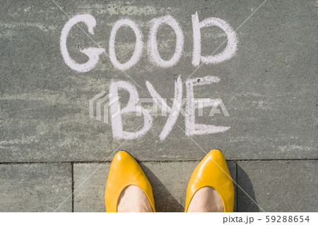 Female feet with text goodbye written on grey sidewalk 59288654