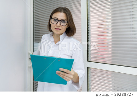 Portrait of positive female doctor, in hospital near the door Portrait of positive female doctor, in hospital near the door 59288727