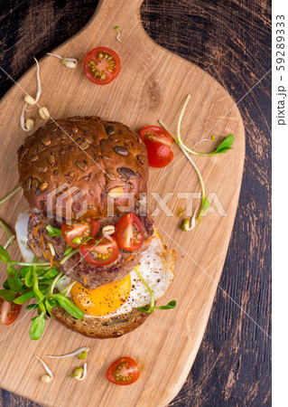 Burger with cherry tomato, green sprout and fried egg 59289333