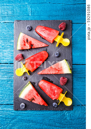 Photo of watermelon slices , fruit ice, blueberries on cutting board Photo of watermelon slices , fruit ice, blueberries on cutting board 59291086