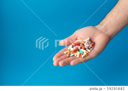 A handful of colored pills on the palm. Medical 59291682