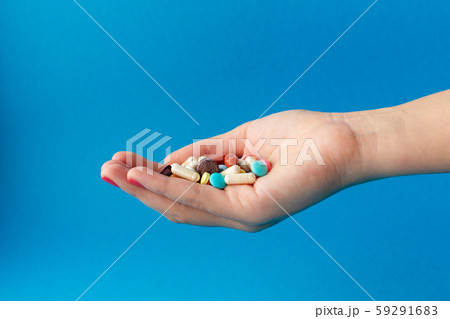 A handful of colored pills on the palm. Medical A handful of colored pills on the palm. Medical 59291683