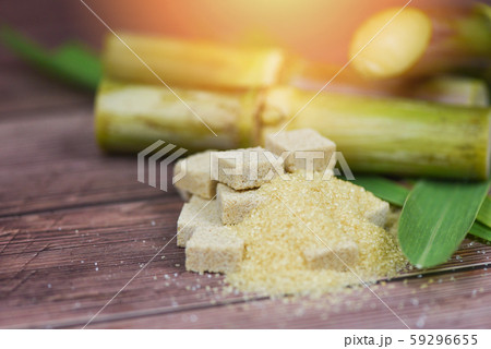 Brown sugar cubes and sugar cane on wooden table 59296655