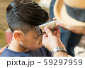 Closeup face of a good looking young asian teenager boy getting a haircut by a barber, hairdresser's hand with electric clipper neatly trim for sharp look and the style. Professional haircut, Handsome 59297959