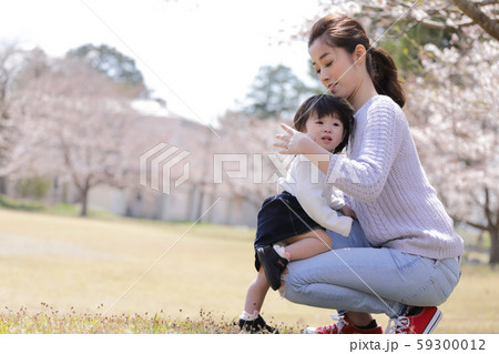 抱っこを要求する子供を抱き上げるお母さんの写真素材