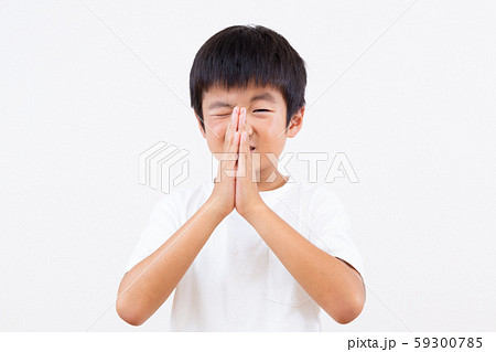 お願いポーズをする男の子の写真素材