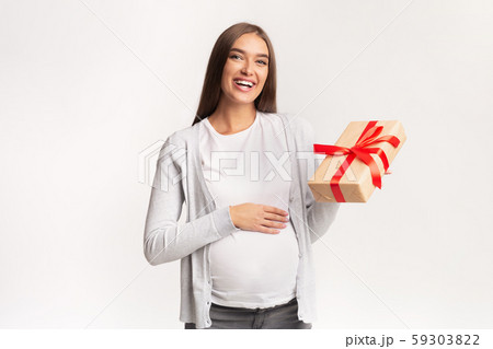 Happy Pregnant Lady Standing Holding Wrapped Gift Box, Studio Shot 59303822