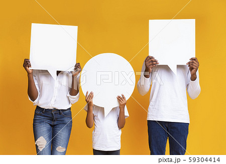 Black family of three covering faces with empty speech bubbles 59304414