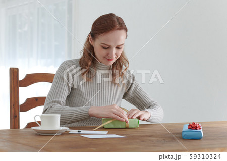 プレゼントとメッセージカードを楽しんで作る外国人女性 59310324