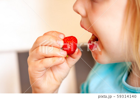 Close up of little girl eating fresh strawberry 59314140