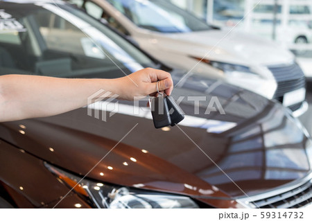 Dealer holding keys to a new car. Modern vehicles. Dealer holding keys to a new car. Modern vehicles. 59314732