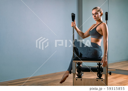 Palates trainer girl posing for a reformer in the gym. Fitness concept, special fitness equipment Palates trainer girl posing for a reformer in the gym. Fitness concept, special fitness equipment 59315855