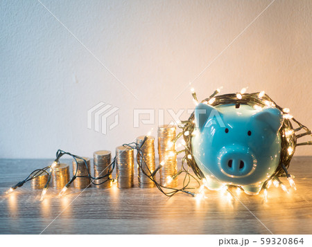 Blue piggy bank with coins pile growth graph and Party lights, Funly saving money for future investment plan and retirement fund concept Blue piggy bank with coins pile growth graph and Party lights, Funly saving money for future investment plan and retirement fund concept 59320864