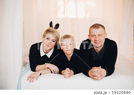 Caucasian family in black on bed.many gift boxes 59320880