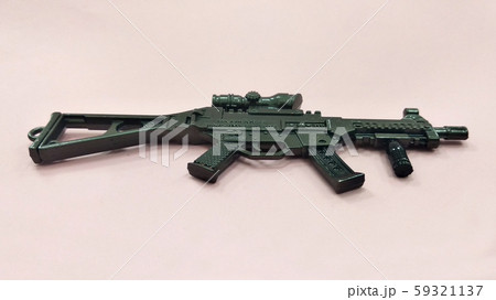 Selected focused on steel model of military gun in miniature scale isolated on red background. Sale as a collector item for military gear collector and hobbyist.  59321137