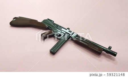 Selected focused on steel model of military gun in miniature scale isolated on red background. Sale as a collector item for military gear collector and hobbyist.  59321148