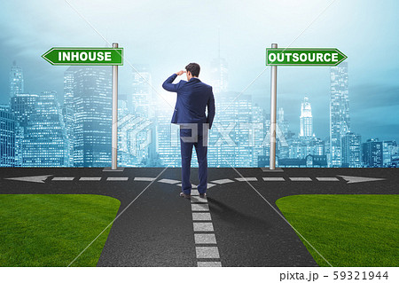 Businessman at crossroads deciding between outsourcing and inhou 59321944