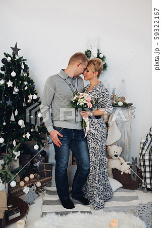 Beautiful couple with bouquet at Christmas tree. 59322167